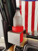 Carica l'immagine nel visualizzatore di Gallery, Plastic bottle in a red coozie in steel cup holder that is mounted in Jeep TJ.  American flag in the background