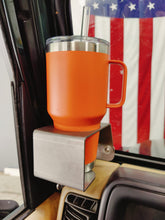 Carica l'immagine nel visualizzatore di Gallery, A silver steel cup holder with an orange cup inserted, mounted on a Jeep TJ dashboard.
