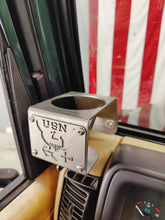 Cargar imagen en el visor de la galería, Metal cup holder with USN logo mounted on drivers side of Jeep Wrangler TJ.  American flag in the background