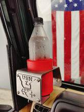 Cargar imagen en el visor de la galería, Plastic bottle with red coozie inside metal cup holder with USN logo mounted on drivers side of TJ Jeep Wrangler