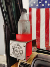Cargar imagen en el visor de la galería, Plastic bottle in a red coozie inside metal cup holder that has USCG logo mounted on drivers side of TJ Jeep Wrangler