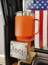 Cargar imagen en el visor de la galería, Orange cup in a metal cup holder that has a "Jeep Dog" logo mounted in a Jeep Wrangler TJ